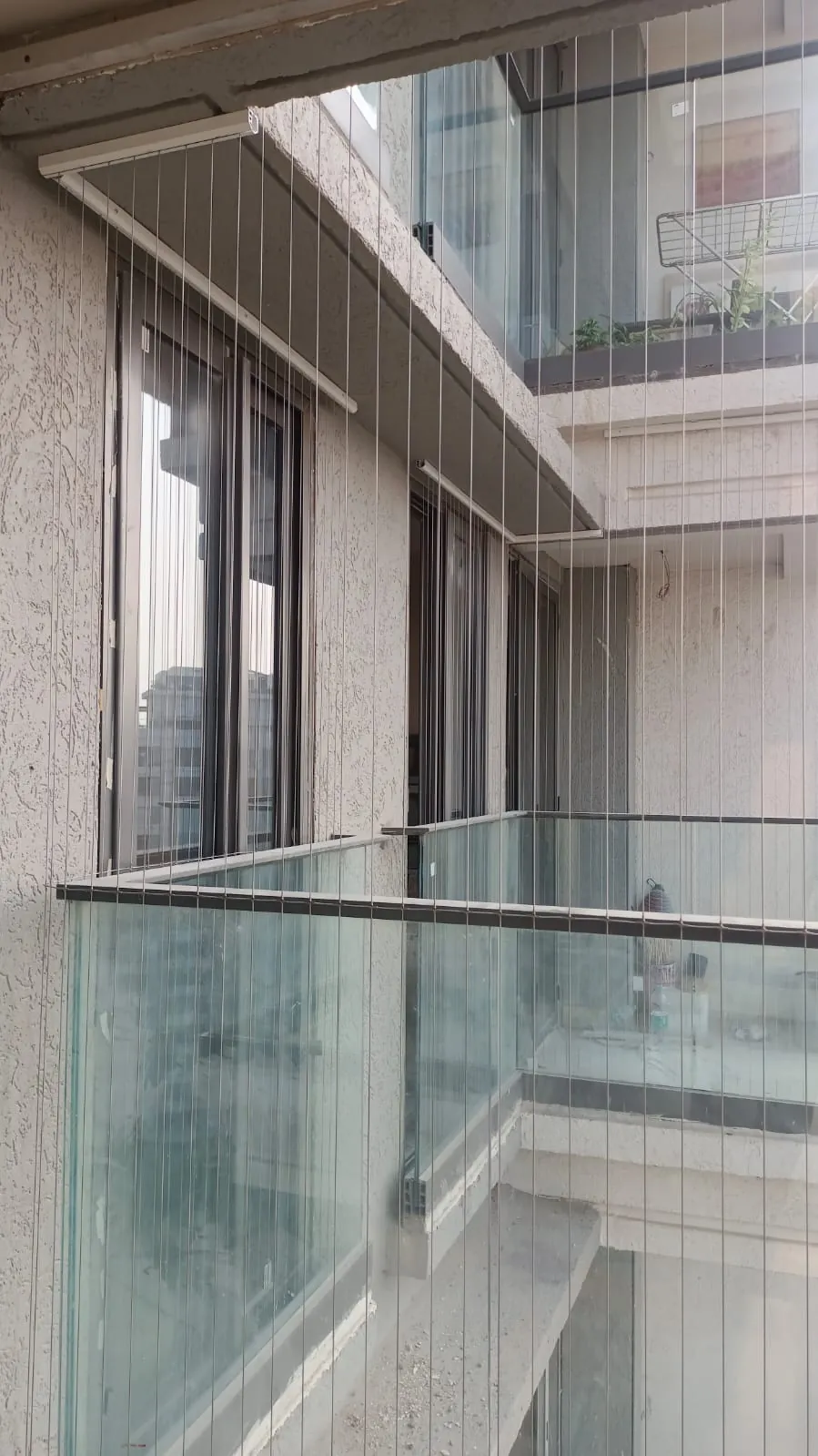 Invisible grill over a glass-railing balcony in a Mumbai apartment tower