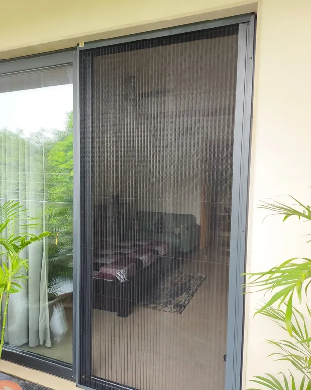 Mosquito net fitted on a balcony sliding door, with the living room visible through the fine dark mesh