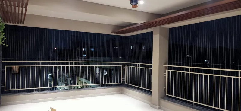 Wide terrace protected by invisible grills above an existing railing, at night